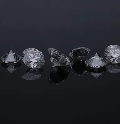 A group of silver diamonds on top of a black surface.