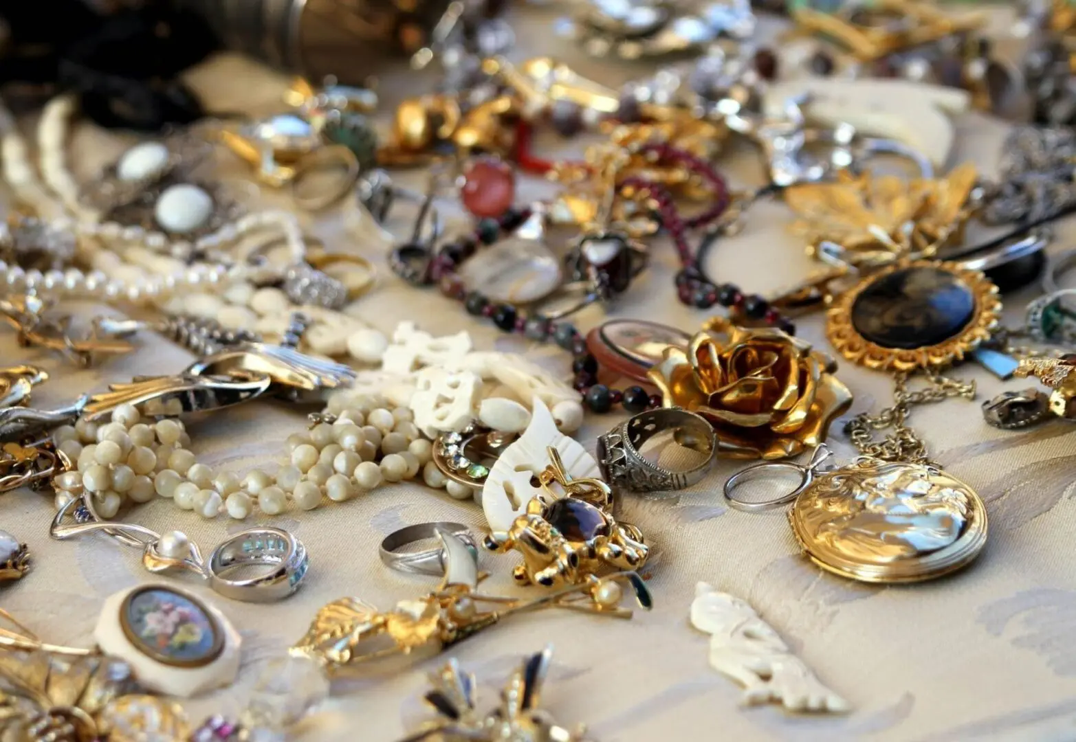 A table covered with lots of jewelry and other items.