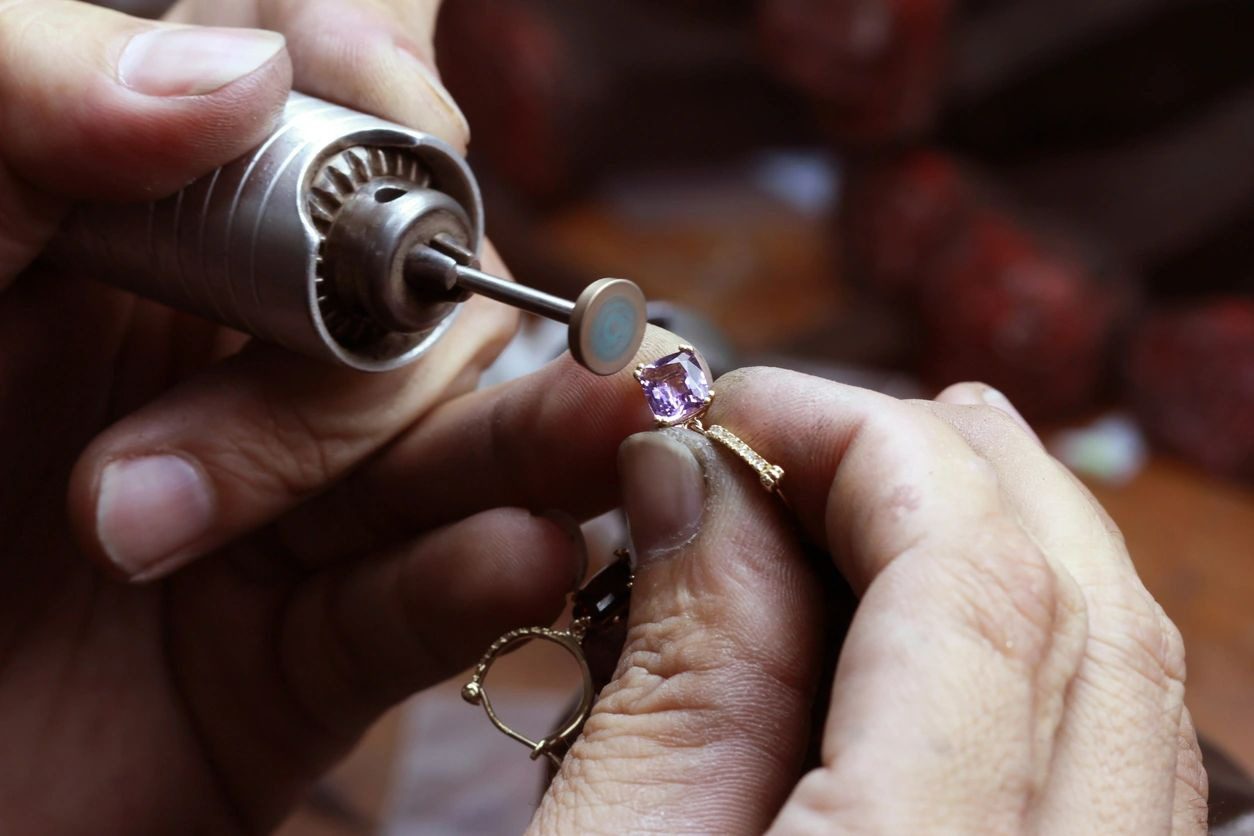 A person is working on a ring with a screwdriver.