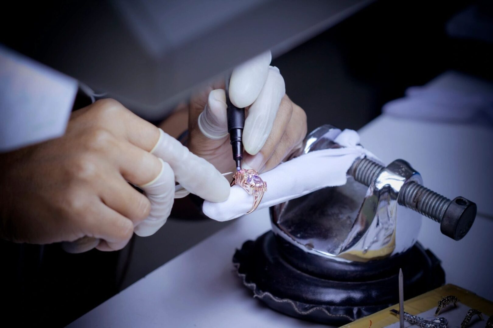 A person is using an electric device to repair a broken watch.