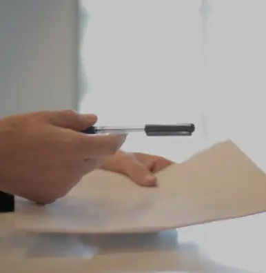 A person is writing on paper with a pen.