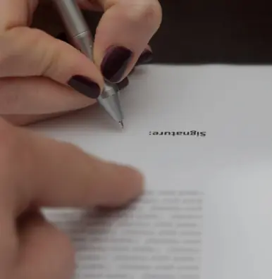 A person writing on top of a piece of paper.