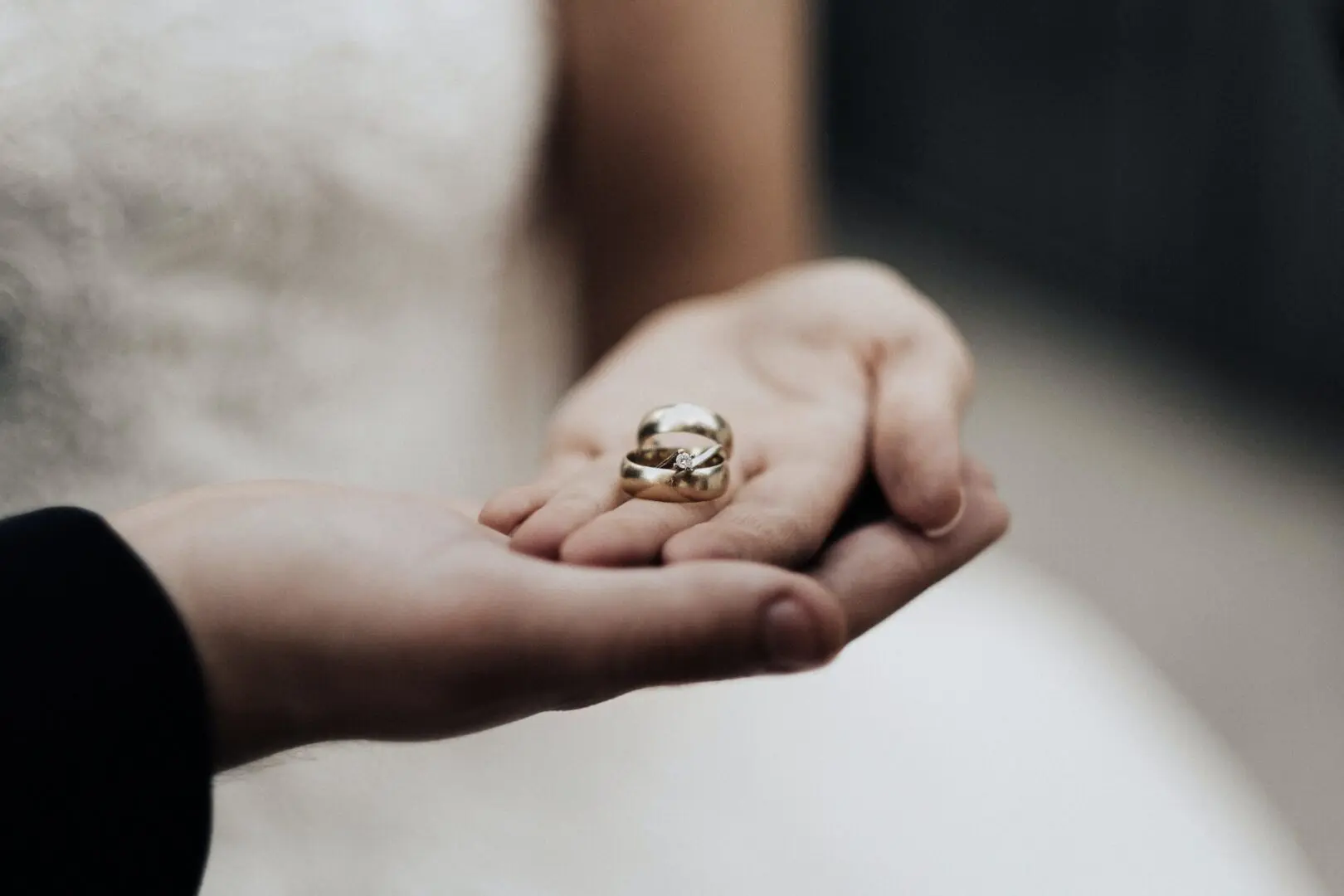 A woman holding her wedding ring in her hand.