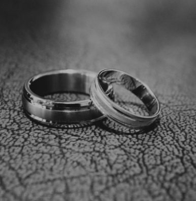 Two wedding rings sitting on top of a table.