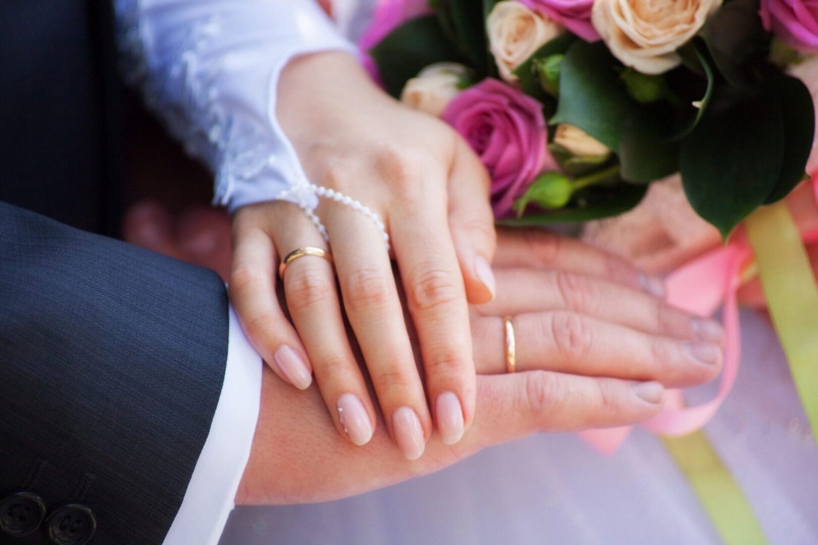 A close up of two hands with wedding rings on